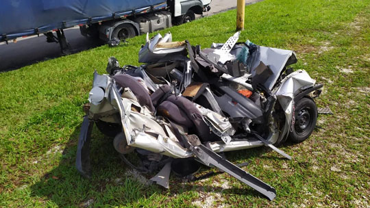 Casal e criança morrem após carro ser prensado entre carretas; Corsa ficou destruído