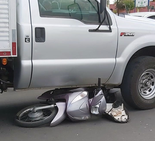 Moto para embaixo de caminhão após colisão em Valente; mulher ficou ferida